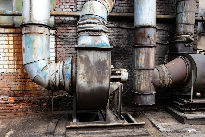 An old rusty ventilation unit in an abandoned metal processing plant.