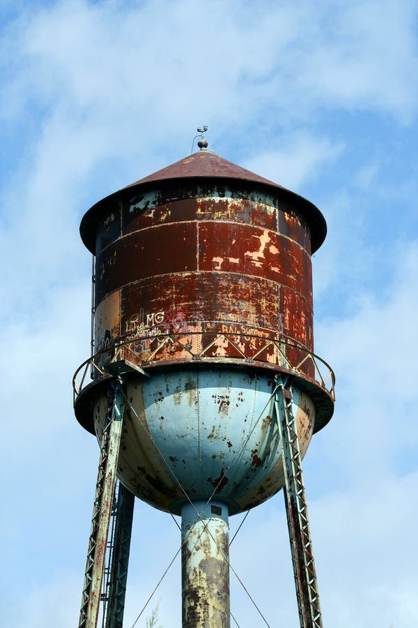 Old rusty watertower against blue sky