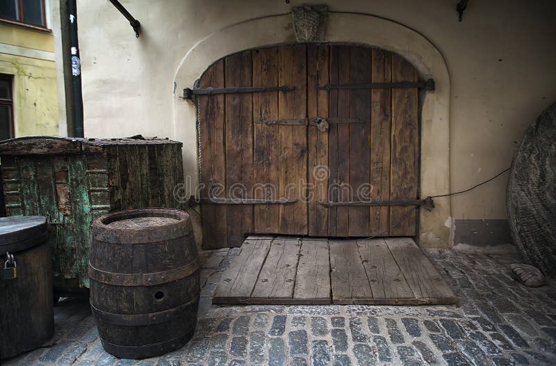 Old rusty wooden gate with barrel as a background