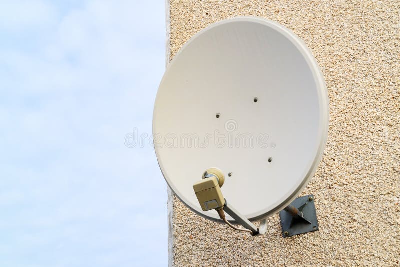 Old Satellite Dish Mounted on the Wall of the House, the Wall of the
