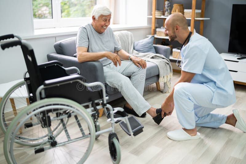Old Senior Home Care Patient With Nurse. Old Senior Home Care. Nurse Helping Patient To Dress Shoes