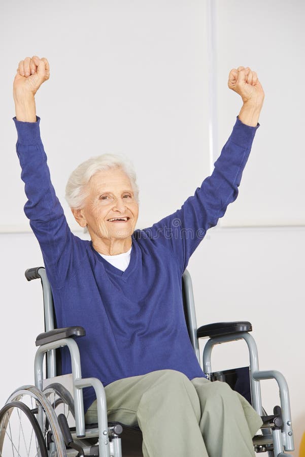 Old senior woman in wheelchair cheering