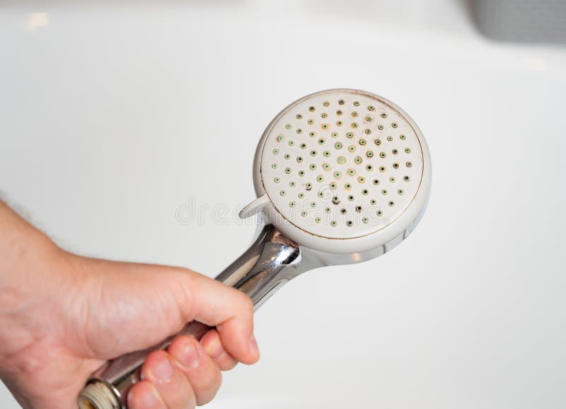 Old shower head. Limescale water stone buildup. stock photo