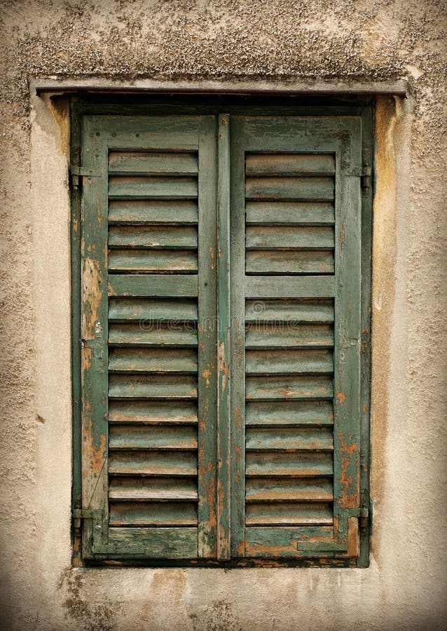 Two Old Windows with Closed Shutters on an Old House Stock Photo