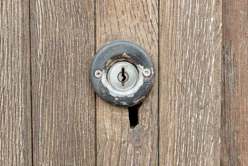 Old small round key hole on an antique worn wooden door up close, keyhole, simple lock front view, object closeup, frontal shot royalty free stock photos