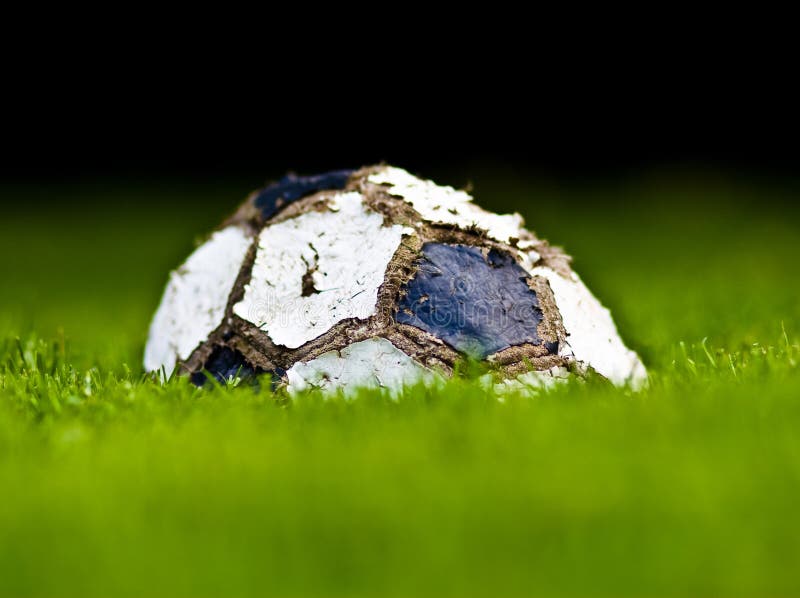 Old soccer ball on grass