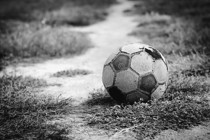 Old soccer ball lying on the grass for street football before the start of the game.