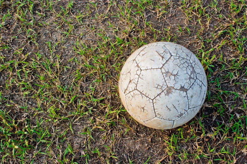 Old Soccer Ball. Poor school soccer field.