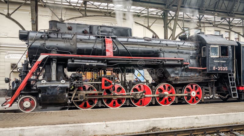 Old Soviet vintage black retro train with a red star at the railway station in Lviv produces steam from the pipes and the passeng royalty free stock photo Old Soviet vintage black retro train with a red star at the railway station in Lviv produces steam from the pipes and the passeng royalty free stock photo