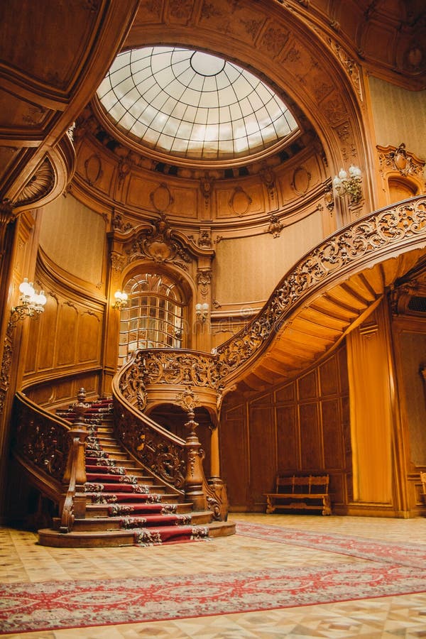 Old spiral wooden staircase with vintage railing indoors. luxury carved wood interior in the hall of an aristocratic palace. rare stock image Old spiral wooden staircase with vintage railing indoors. luxury carved wood interior in the hall of an aristocratic palace. rare stock image