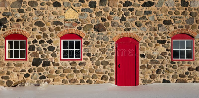 Old Stone Barn with Bright Red Door and Three Windows