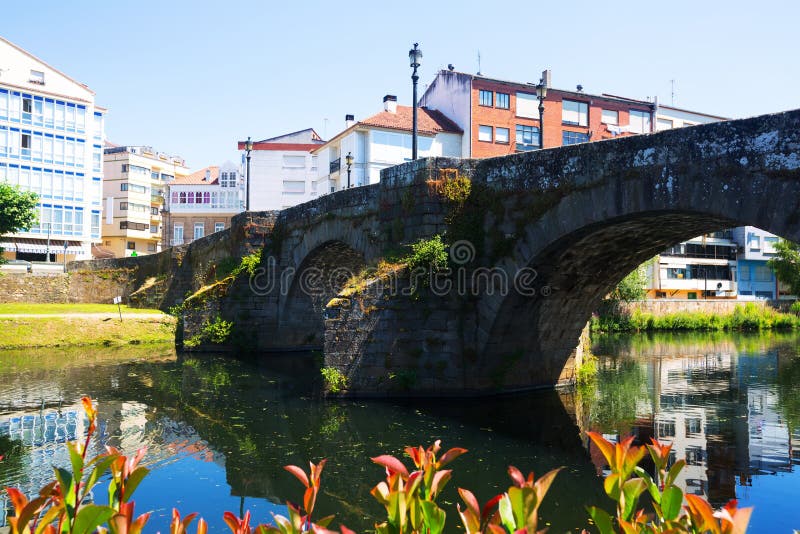 Cabe river and old stone bridge at Monforte de Lemos in sunny summer day. Galicia, Spain