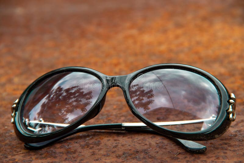 Old Sunglasses in Cloudy Day on Rusty Metallic Surface Background Stock