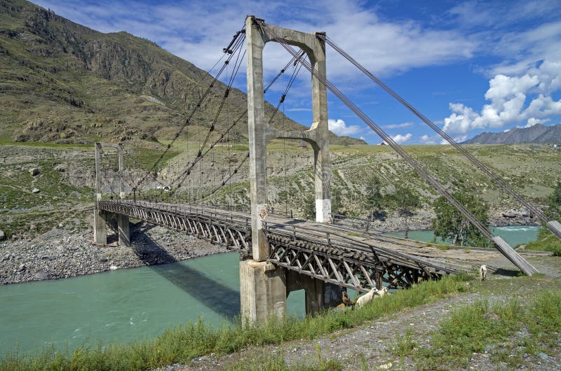 Old suspension bridge across mountain river, Altai, Russia.