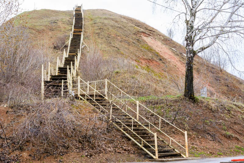 An old tall wooden staircase rises on a large mountain. The ladder symbolizes growth, ascension, aspiration, willpower. Tetyushi, royalty free stock images An old tall wooden staircase rises on a large mountain. The ladder symbolizes growth, ascension, aspiration, willpower. Tetyushi, royalty free stock images