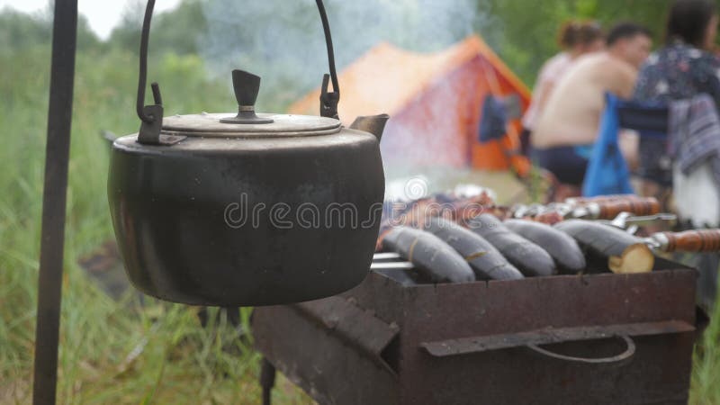 Old teapot boils on campfires. Fire, kettle, camping. Set fire to boil hot water in the kettle.