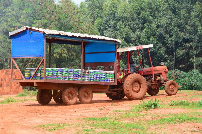 tractor pulling hay ride cart on trail through trees stock