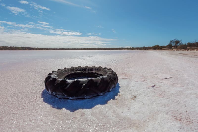 Old tractor tyre laying on the pink salty surface of Lake Beckin stock photography Old tractor tyre laying on the pink salty surface of Lake Beckin stock photography
