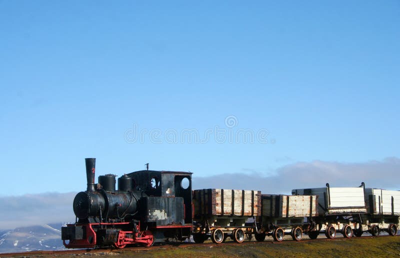 An old train with mountains in the background