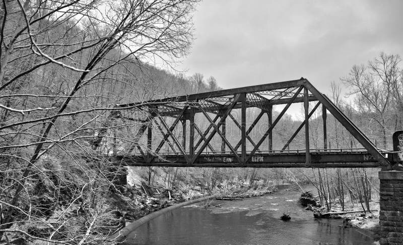 An old train bridge crossing a river on a snowy day in northern Maryland in Patapsco State Park near Ellicott City, Maryland. An old train bridge crossing a river on a snowy day in northern Maryland in Patapsco State Park near Ellicott City, Maryland