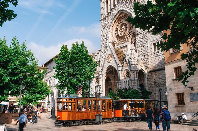 Old tram in Soller in front of medieval gothic cathedral with huge rose window, Mallorca, Spain royalty free stock image Old tram in Soller in front of medieval gothic cathedral with huge rose window, Mallorca, Spain royalty free stock image