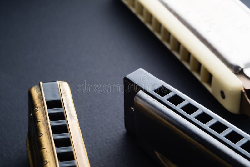 Old two diatonic and chromatic harmonica on a dark background. Horizontal orientation. copy space