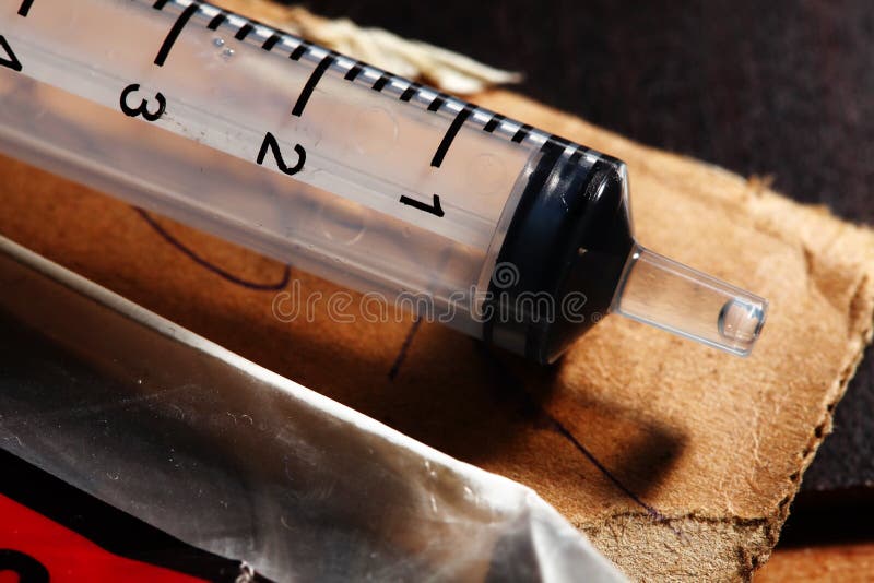 Used Syringe on the Ground Drugs Addiction Equipment. Stock Photo