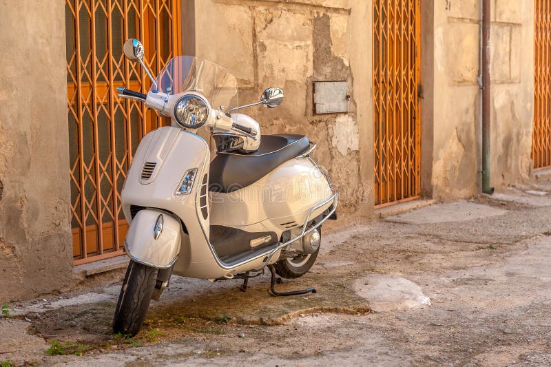 White Vespa on a small ugly street in the old town, Italy