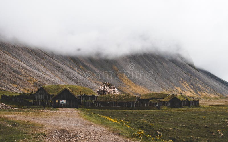 Old viking village in iceland with foggy hill. old wooden buildings covered in grass