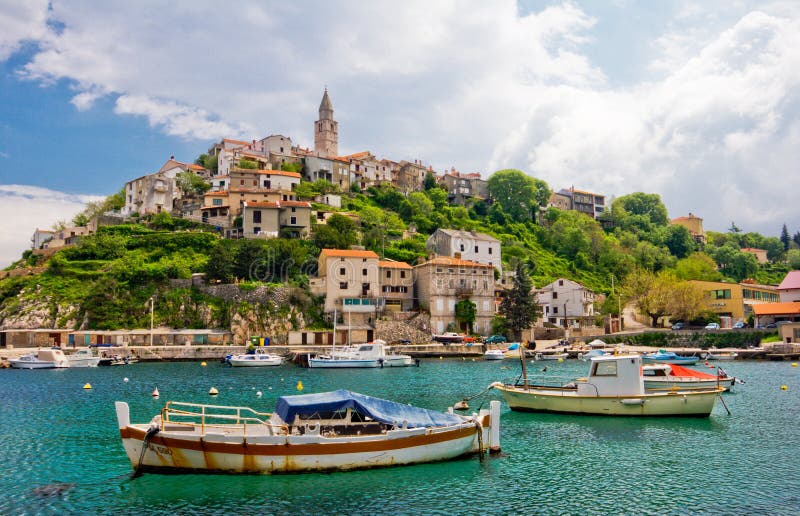 Old village on the hill at seaside with fishing boats in foreground