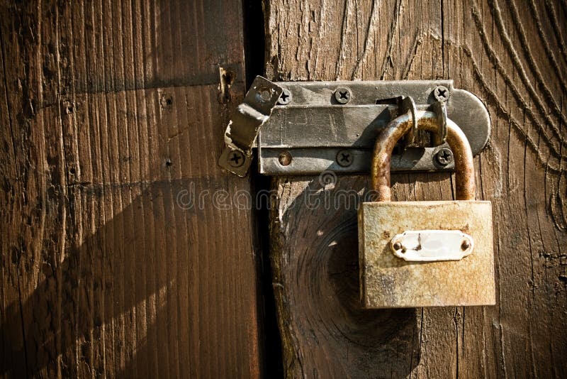 Old vintage antique padlock on wooden door