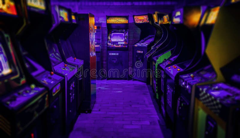 Old Vintage Arcade Video Games in an empty dark gaming room with purple light