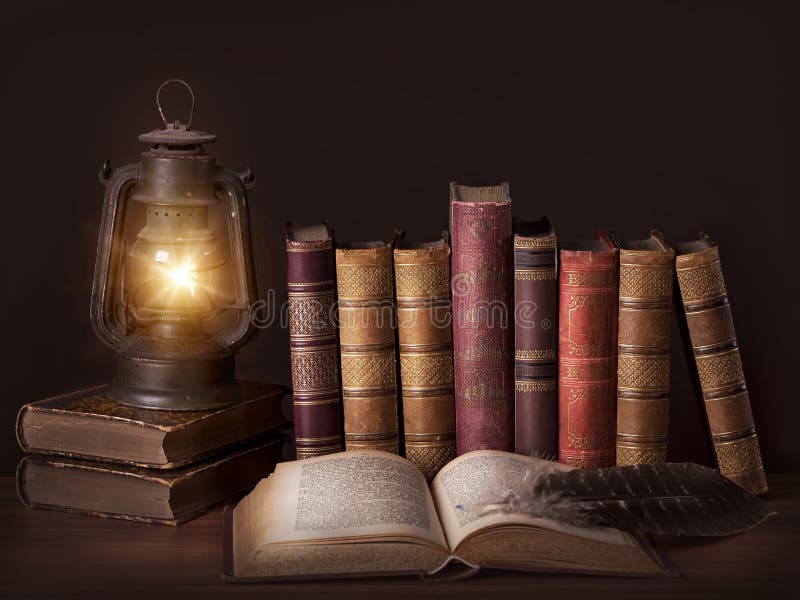 Vecchi libri d'epoca in piedi in una riga e una vecchia lampada.