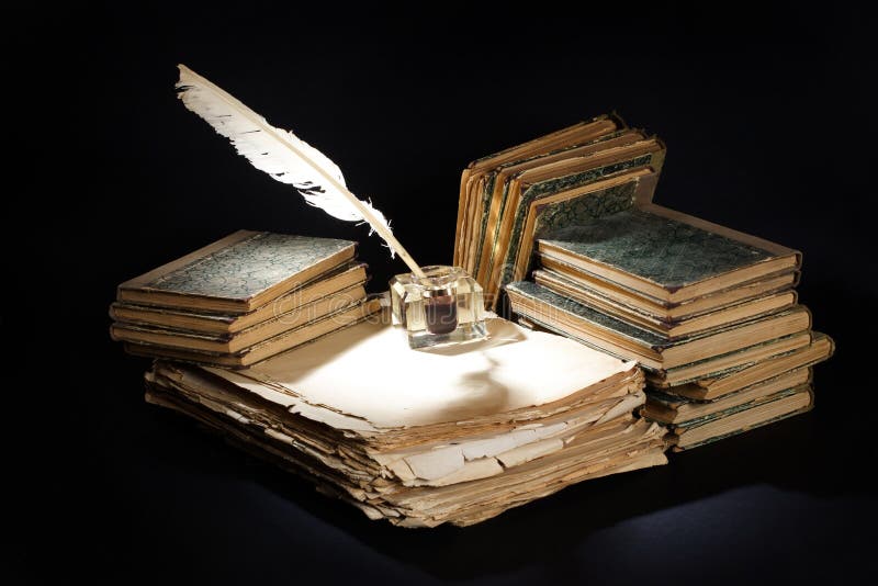 Old vintage fountain pen, books and inkwell on a black background