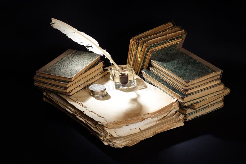 Old vintage fountain pen, books and inkwell on a black background