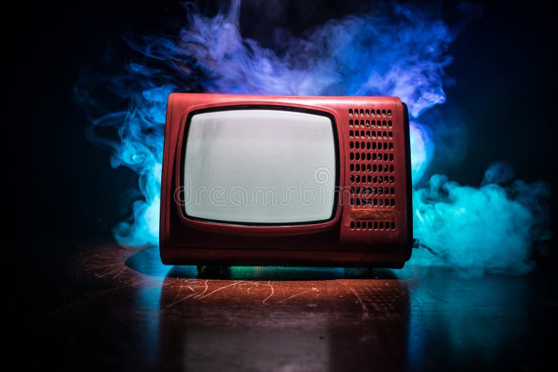 Old vintage red TV with white noise on dark toned foggy background. Retro old Television reciever no signal