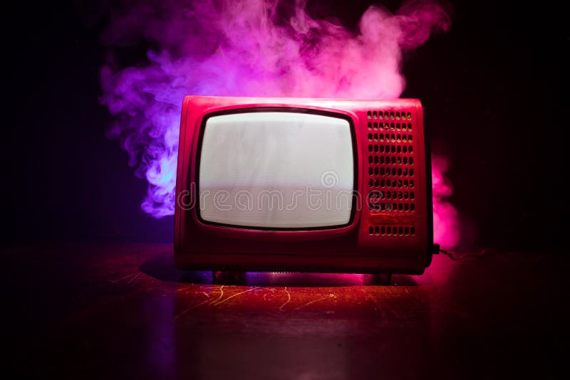 Old vintage red TV with white noise on dark toned foggy background. Retro old Television reciever no signal