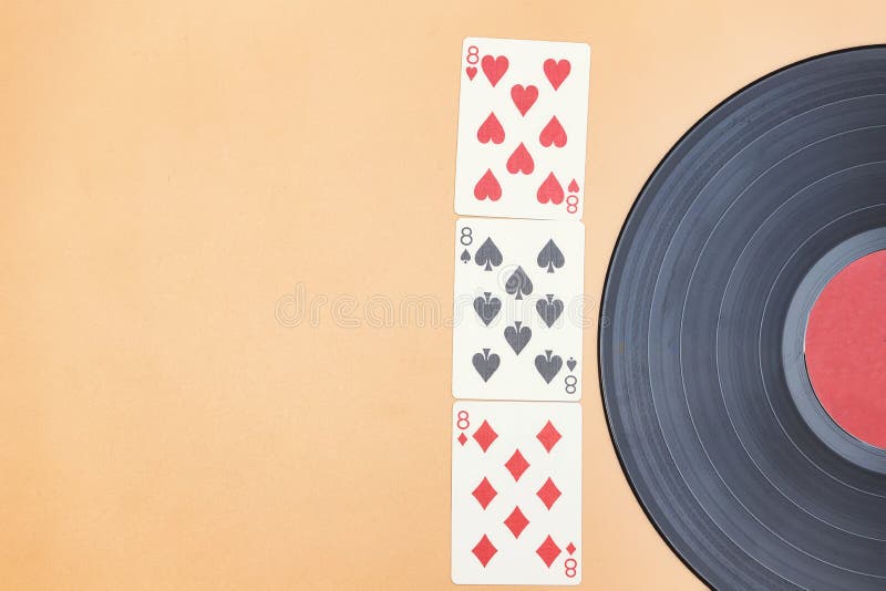 An old vinyl record and lucky three eights in cards stock photo