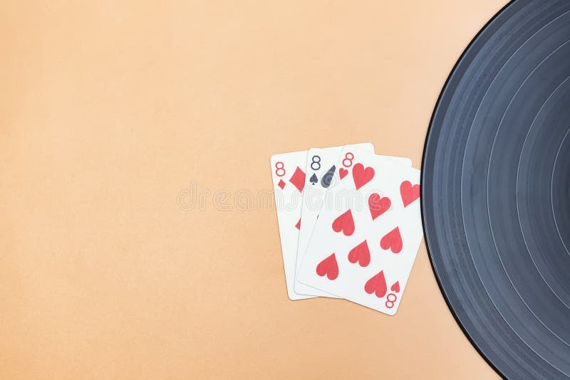 An old vinyl record and lucky three eights in cards stock photography