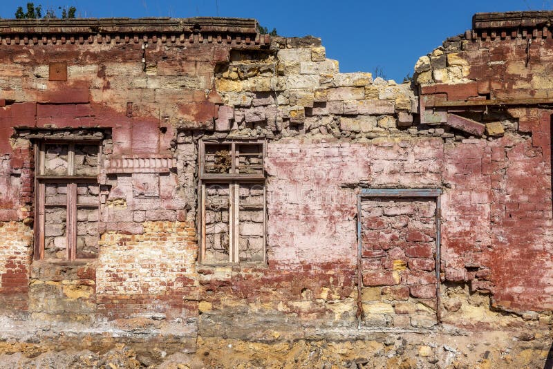 Old wall of destroyed house. Old powder wall with walled window and gates, doors. Ruined house. Remains of old houses. Apocalypse