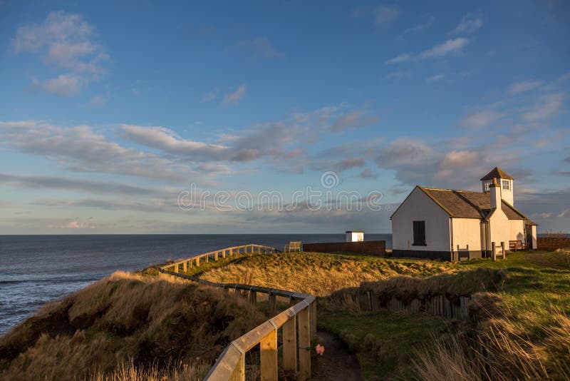 The old Watch House on the cliffs above Seaton Sluice in Northumberland, England at sunset
