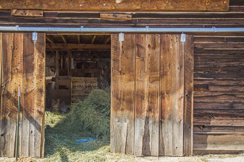 Old weathered sliding barn door hay sunlight