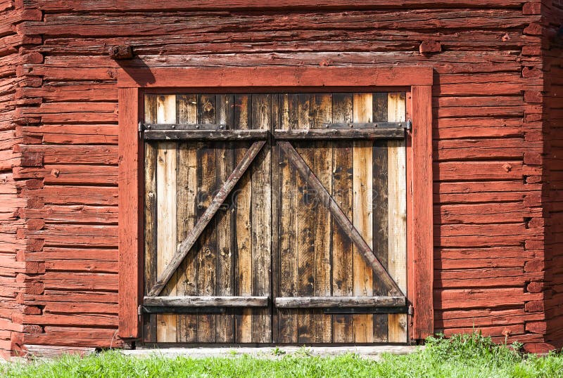 Old weathered barn door on a historic barn painted with the famous Falu red paint