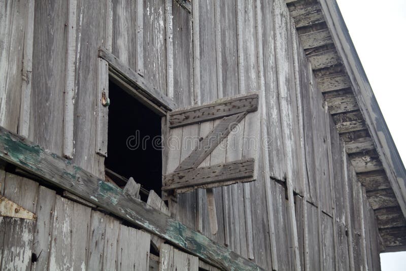 Old Weathered Gray Barn Open Hay Loft. An old, weathered, gray, wooden, abandoned Indiana barn with an open hay loft door braced by a letter Z support wastes royalty free stock photo Old Weathered Gray Barn Open Hay Loft. An old, weathered, gray, wooden, abandoned Indiana barn with an open hay loft door braced by a letter Z support wastes royalty free stock photo