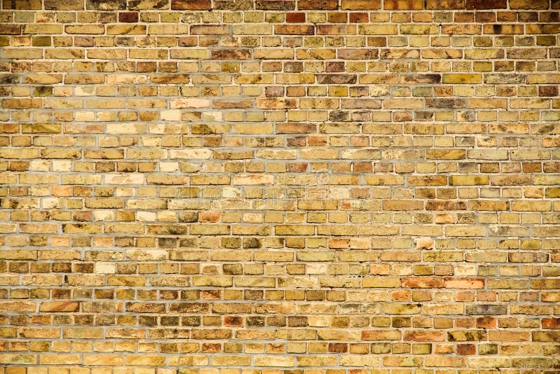 Old and weathered grungy yellow and red brick wall as seamless pattern texture wall background