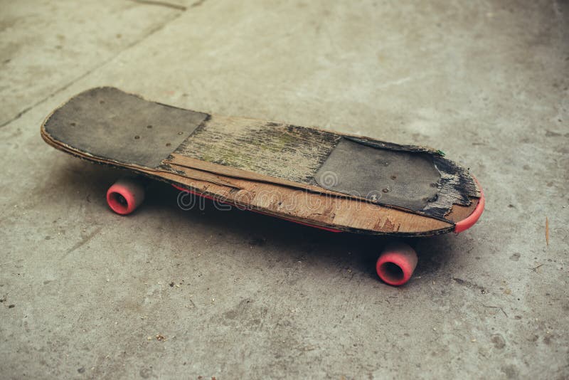 Old weathered skateboard on concrete surface royalty free stock images