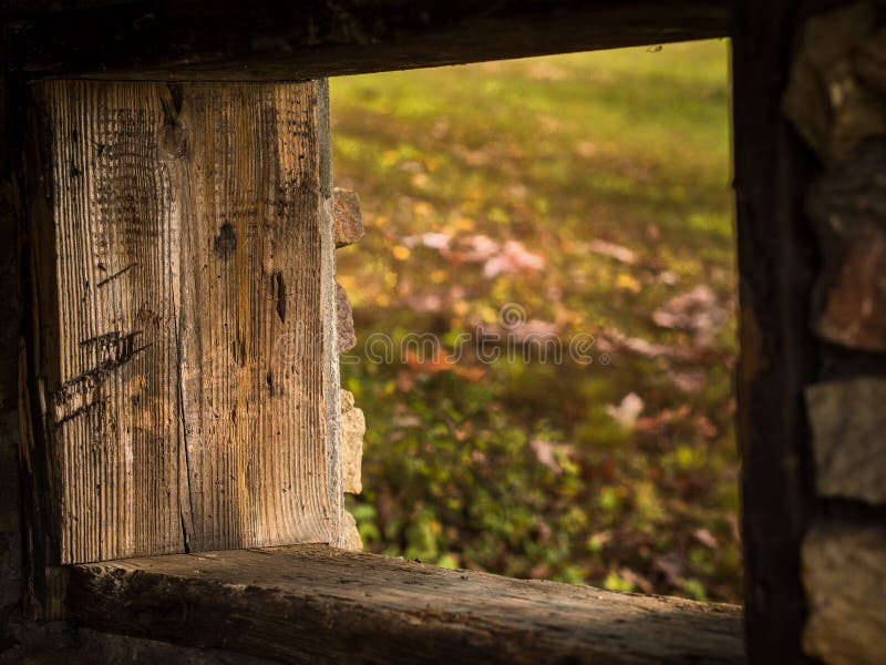Old Window Opening Framed by Wooden Boards with Grass Outside Stock