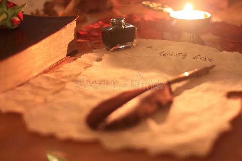 Old paper with feather pen and ink, a candle and Bible on wooden table writing