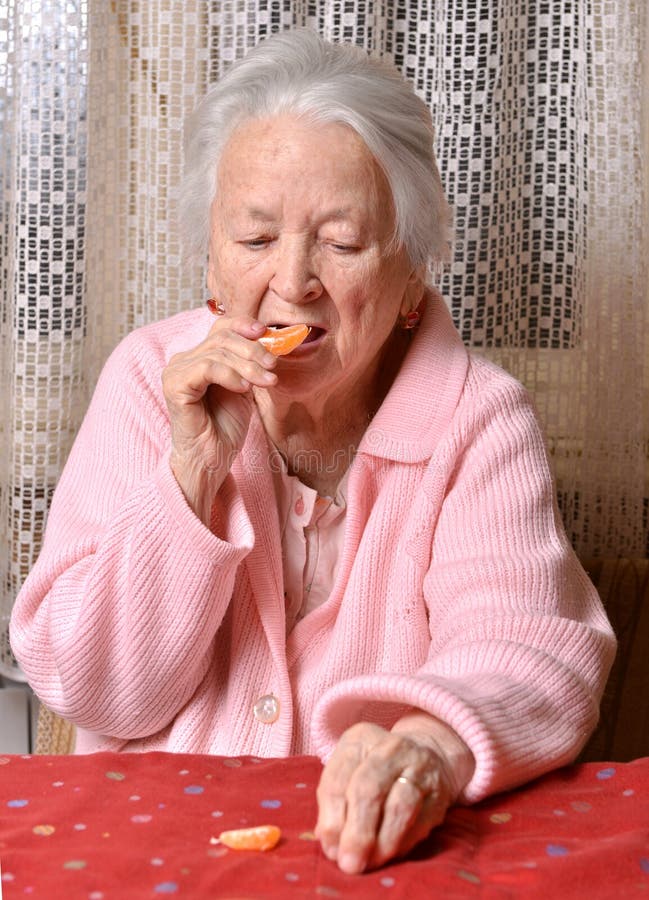 Old woman eating tangerine stock image. Image of orange 47961837