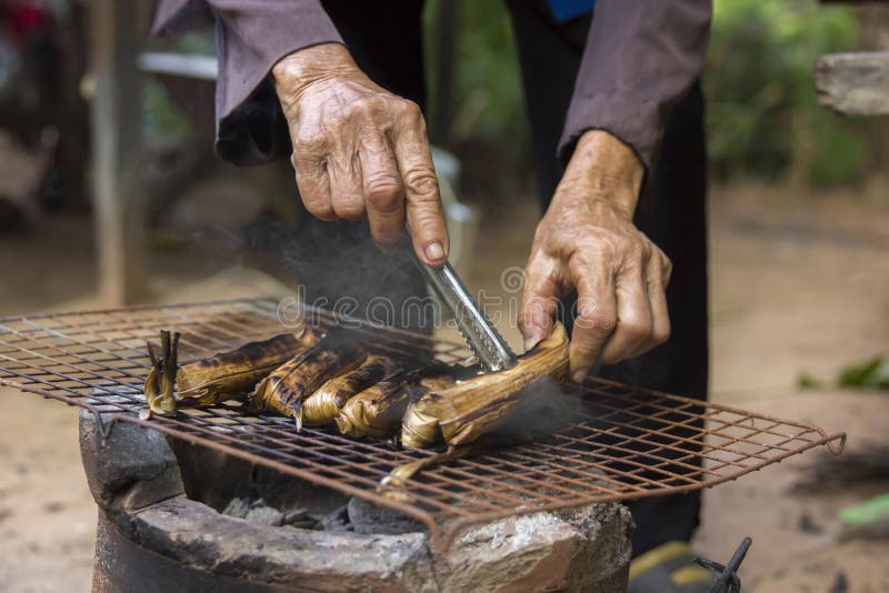 Old woman is grilling in a grill stock photos